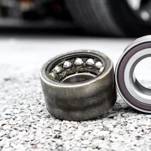 old and new wheel bearings on pavement
