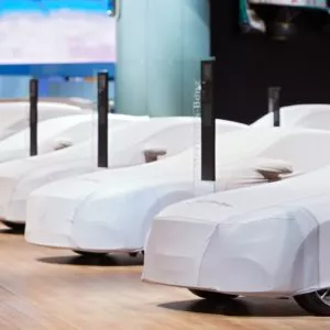 a row of covered cars in auto show