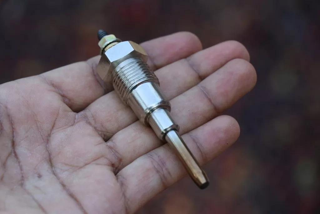 hand holding an automotive glow plug