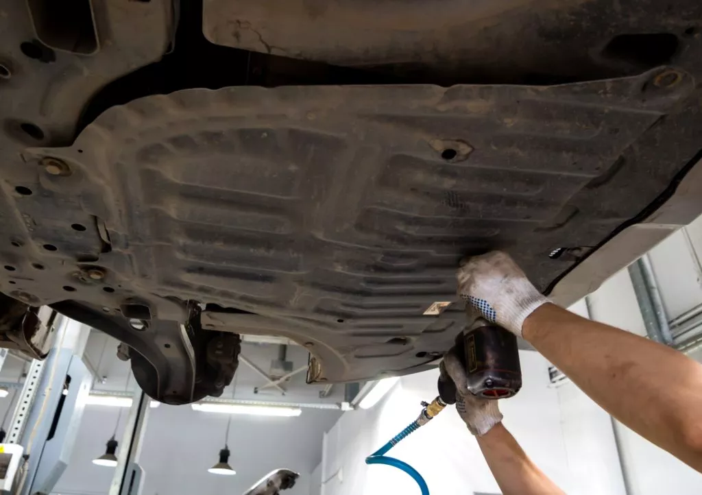 mechanic inspecting vehicle crankcase