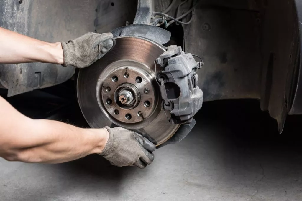 mechanic installing brake disc and pads