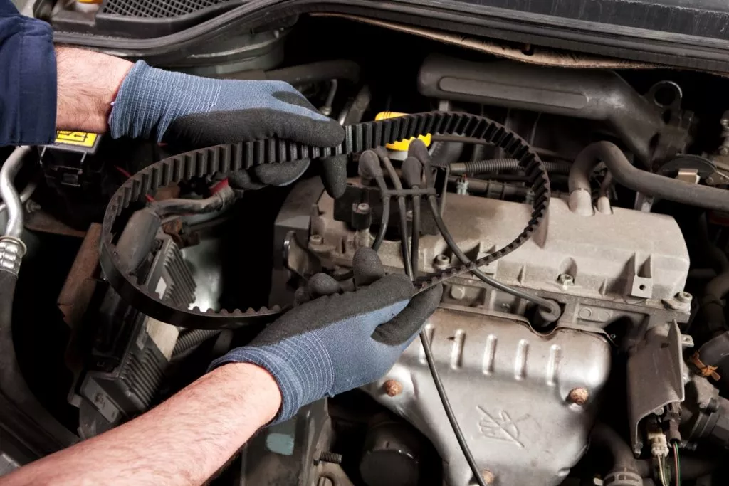 mechanic holding a timing belt