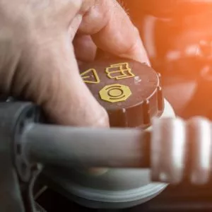 mechanic tightens brake reservoir cap close up