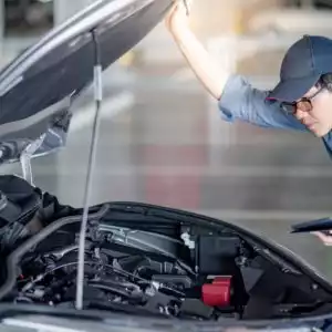 asian male mechanic opens hood looking for pcm