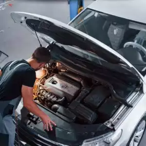 car hood open with man inspecting engine