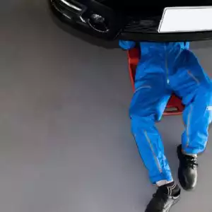 mechanic checking under the car for sensor inspection