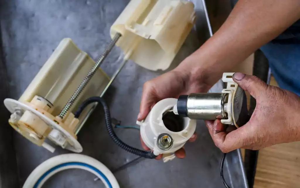 mechanic installing an electric fuel pump manually