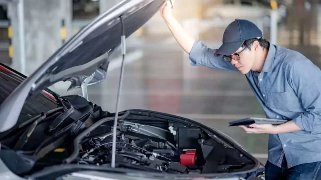 asian male mechanic planning to replace camshaft