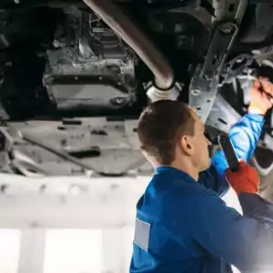 mechanic inspects car brake hose