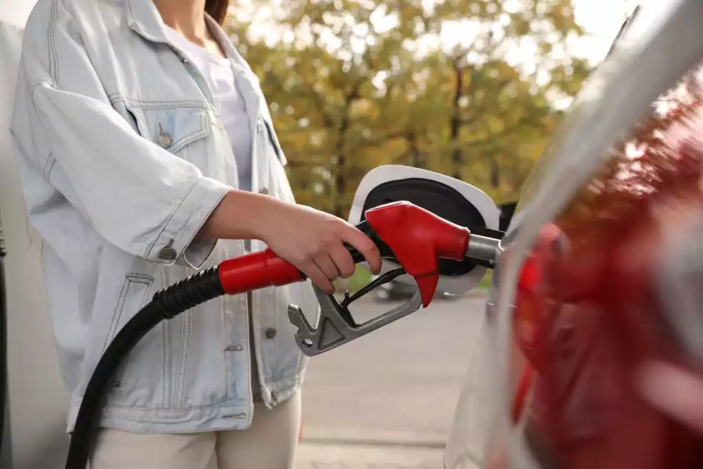 woman refueling car at gas station