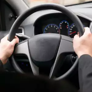 driver holding steering wheel firmly