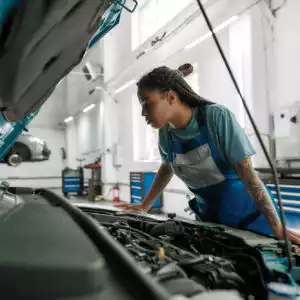 female mechanic looks for the fuel injector causing p0264 code