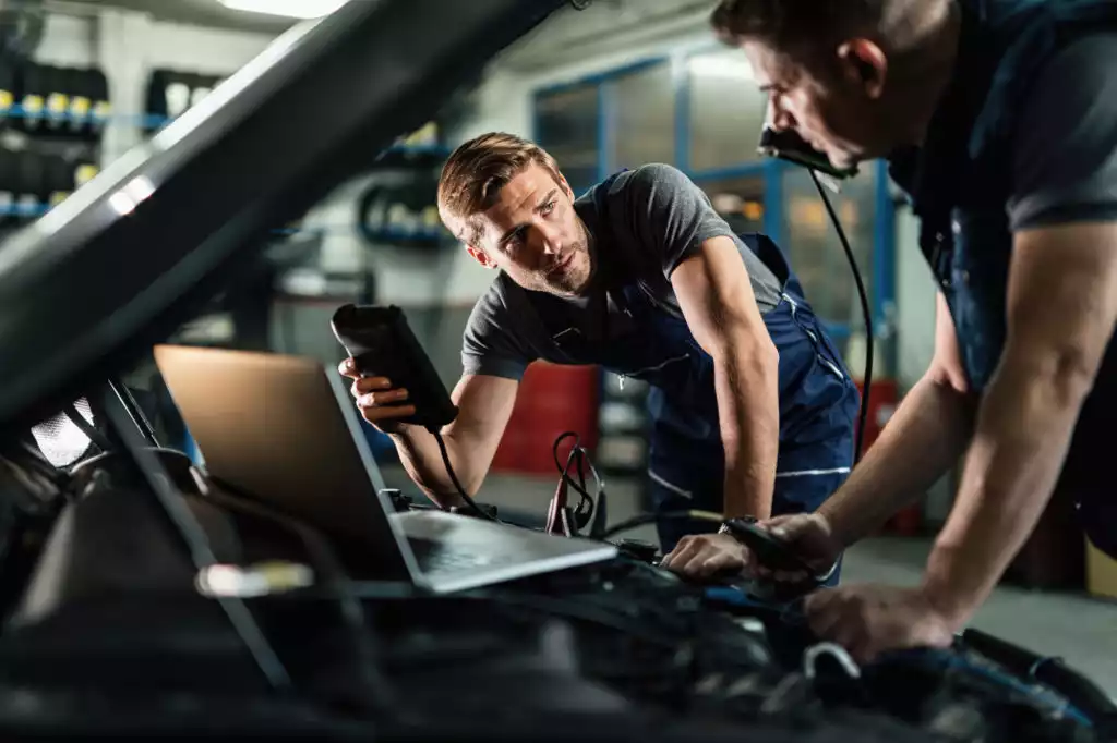 car mechanics performing diagnostic on possible obd code