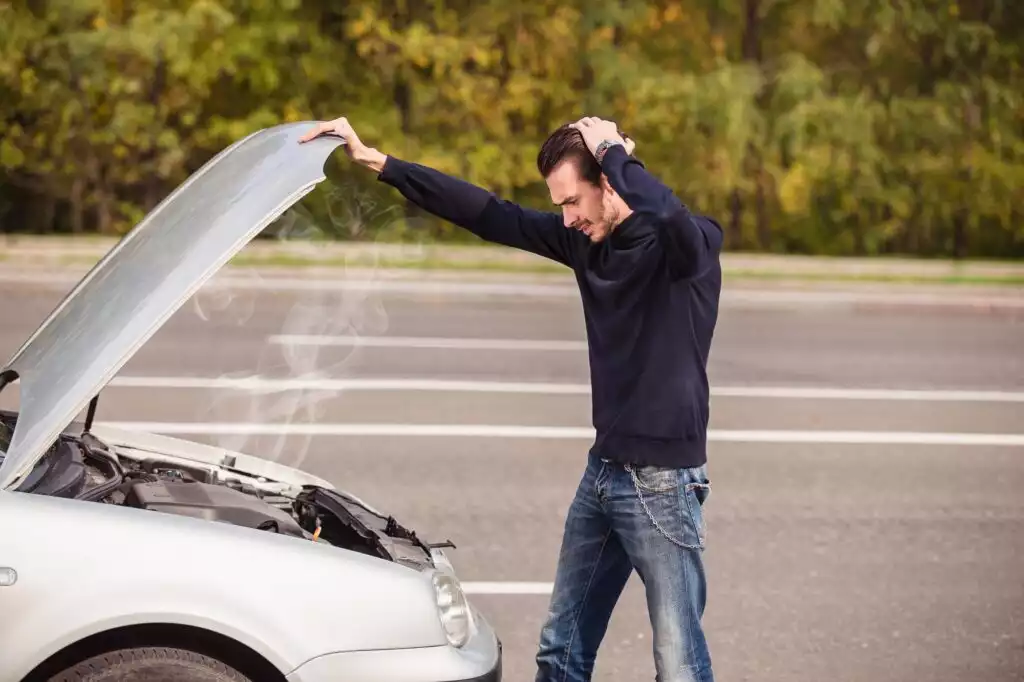 man opening car hood after noticing smoke