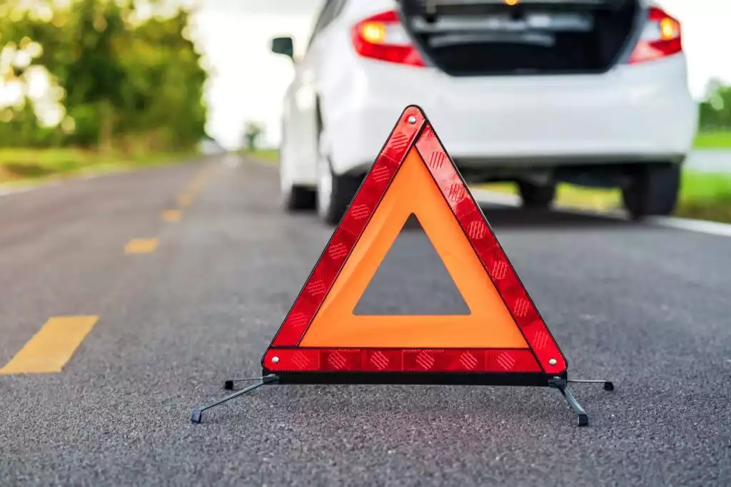 reflective triangle set up with white car in background