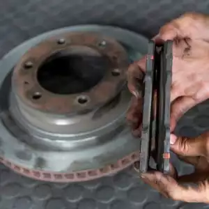 mechanic showing uneven brake pad wear