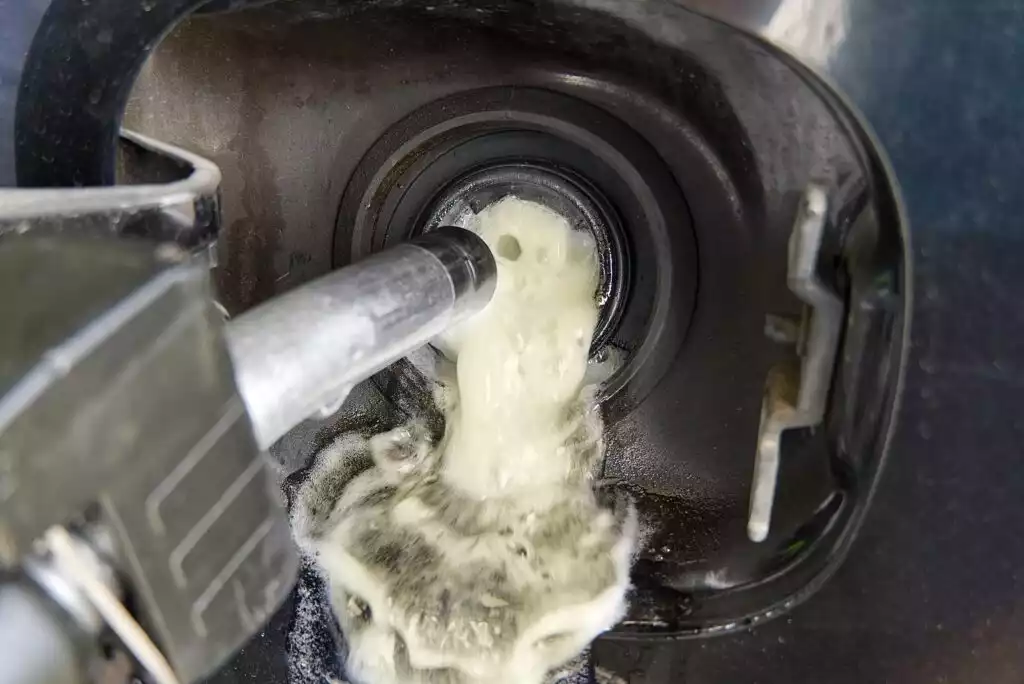 car fuel tank overflowing with fuel