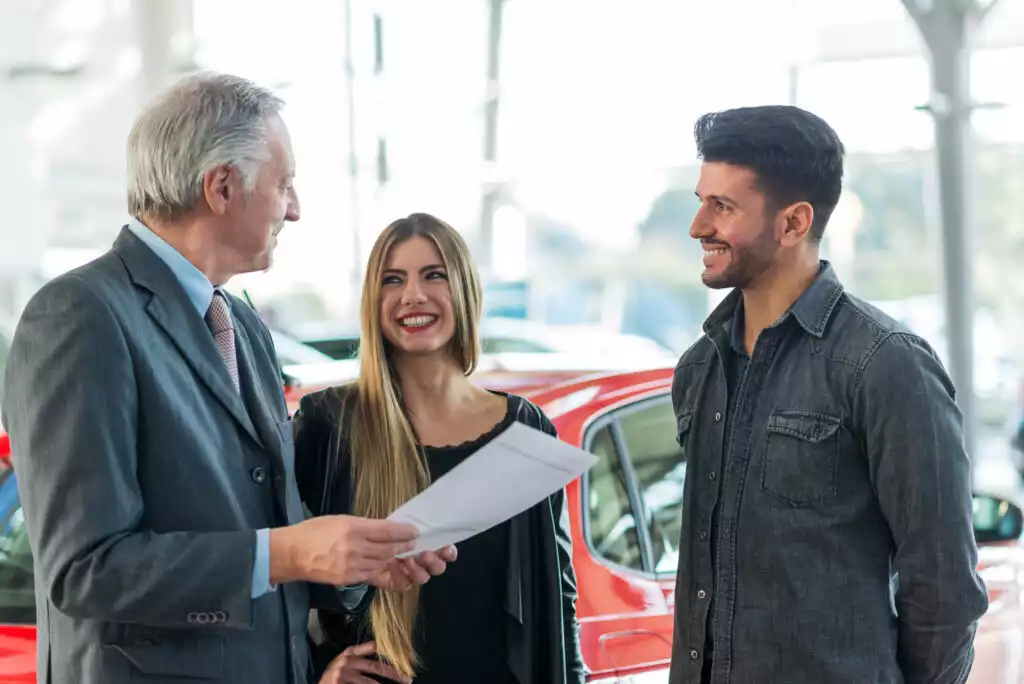 couple trading their old car at a dealership