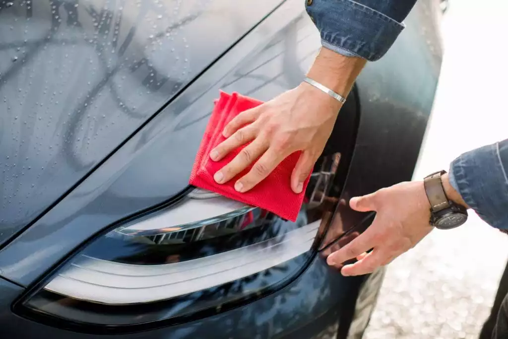 man wiping car with microfiber cloth