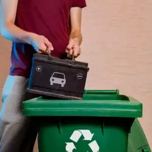 man throwing an old car battery