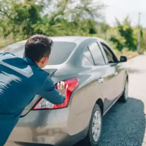 man performing roll start procedure on car