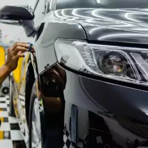 mechanic is coating car with ceramic glass to prevent scratches