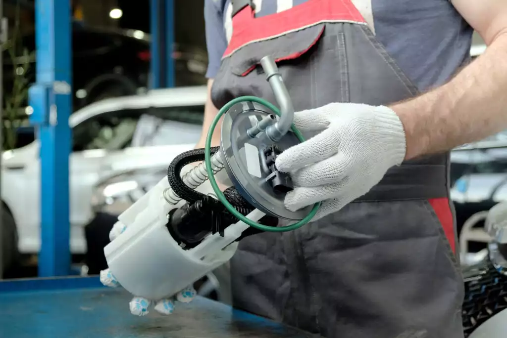 man holding a car fuel pump for inspection