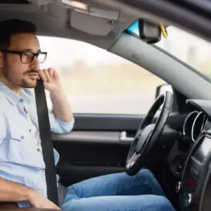 man trying to retract a car seat belt