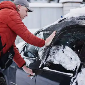 man trying to enter car during winter