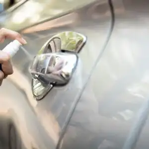 spraying rubbing alcohol to a car door handle