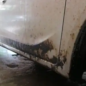 tar on the lower part of a white car
