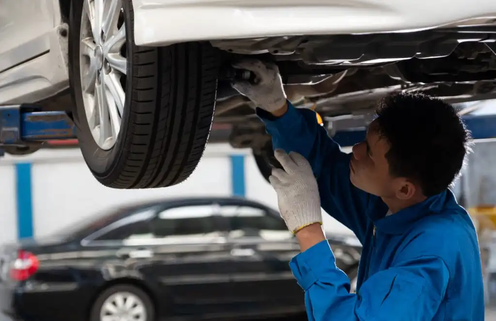 man doing suspension checks on car