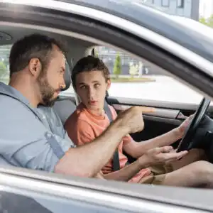 man teaching teen son how to drive