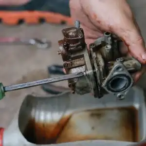 mechanic cleaning a carburetor