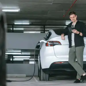 man charging ev at a public space