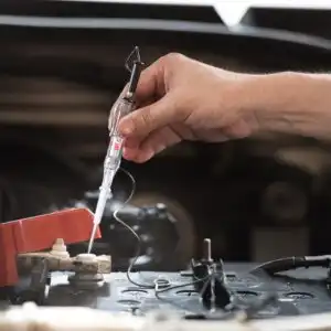 using a test light tool to a car battery