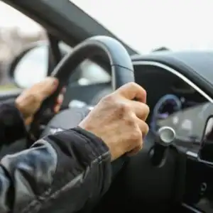 both hands holding the steering wheel