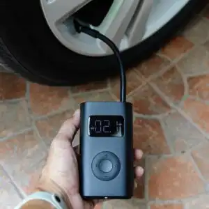 person holding a tire inflator connected to a tire