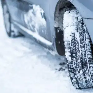 close up shot of snow tires on a snowy road