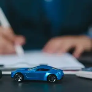 toy car with a person signing a document at the back