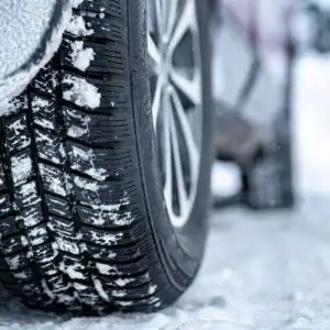 close up shot of a car with winter tires on a snowy road
