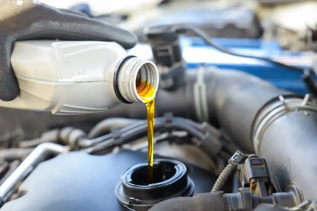pouring replacement engine oil to a car oil reservoir