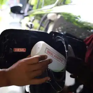 pouring diesel additives to a fuel tank