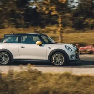 white mini cooper driving in the countryside